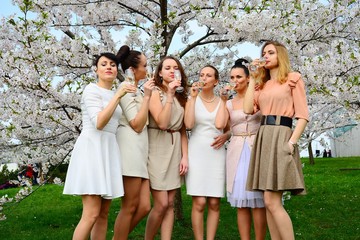 Girls with champagne celebrating in sakura's garden.