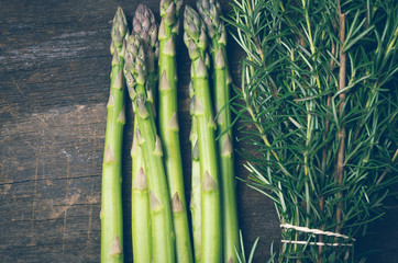 asparagus and bundle of rosemary on wood closeup
