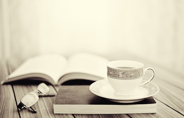 Book and tea/coffee on a wooden table