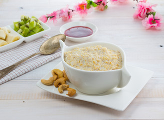 Porridge with kiwi and banana over wooden vintage background