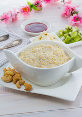 Porridge with kiwi and banana over wooden vintage background