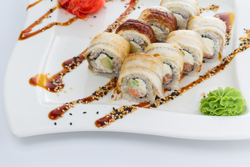 Eel sushi roll with unaghi sauce on a white plate