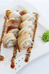 Eel sushi roll with unaghi sauce on a white plate