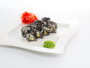 Sushi roll with black caviar with ginger and wasabi on a white plate