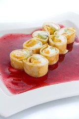 Sweet roll with orange and kiwi on a red plate over white background