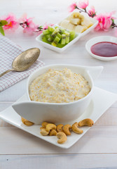 Porridge with kiwi and banana over wooden vintage background