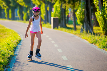 Rollerblading. Roller skating young girl in park rollerblading on inline skates. Caucasian young...