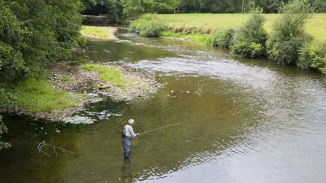 Upper view of fly-fisherman fishing in river, basque country