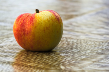 Autumn ripe apple on a brown table