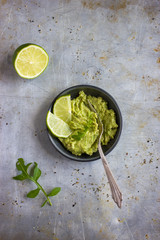 Guacamole dip and lime on rustic  background