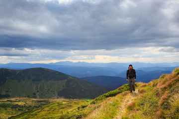 Fototapeta premium Man traveler hiking in the mountains
