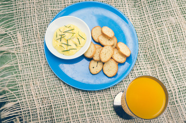 Blue plate with small slices of bread on it and butter rosemary