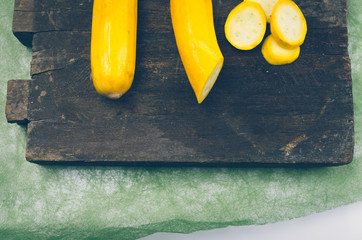 fresh ripe zucchinis lying on wooden board, one of them half