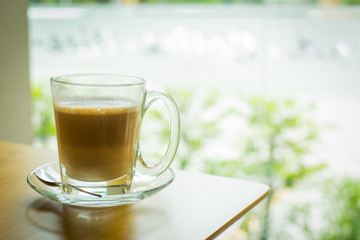 hot latte coffee on wooden table, vintage and retro style