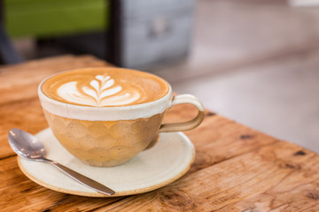 Hot art Latte Coffee in a cup on wooden table.