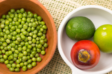 ceramic terracota bowl with raw green peas next to white plate
