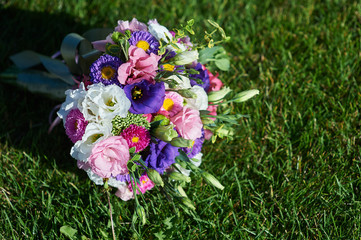 Obraz na płótnie Canvas white wedding bouquet lying on green grass