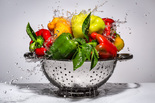 Colorful peppers in drops of water in a colander.