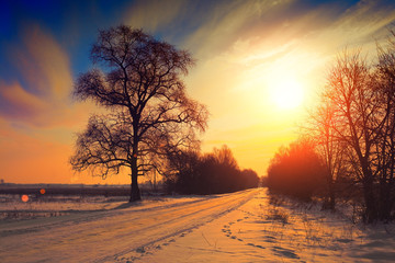 Landelijk winterlandschap bij zonsondergang