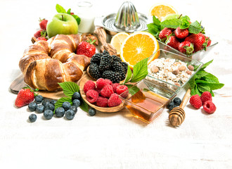 Breakfast with croissants, muesli, fresh berries, fruits. Health
