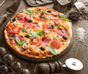 Pizza with mushrooms, salami and tomatoes.