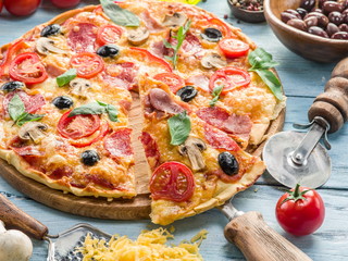 Pizza with mushrooms, salami and tomatoes.