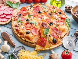 Pizza with mushrooms, salami and tomatoes.