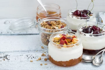 Poster dessert with cream, peach and cherry jam in glass jars on white © cook_inspire