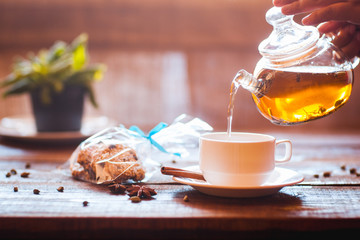 Green tea flows from a teapot in a cup