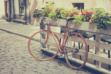Fototapeta na wymiar Bicycle on old street. Vintage stylized.