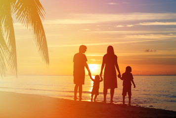 Fototapeta na wymiar happy family with two kids having fun on sunset beach