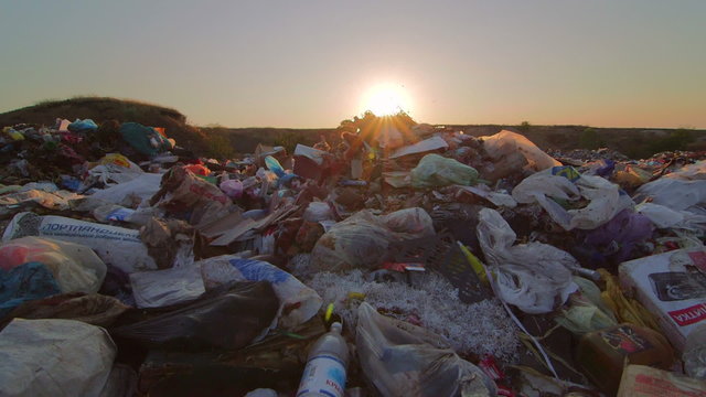 Sun setting over landfill site of domestic waste jib shot