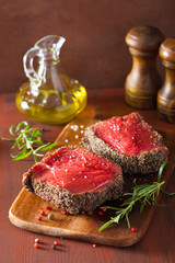 raw beef steak with spices and rosemary on wooden background