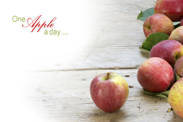 red apples on rustic gray wood, background fade to white