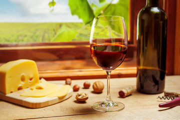 Red wine bottle and glass on wooden table