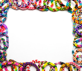 Frame border made out of loom bracelets on a white background