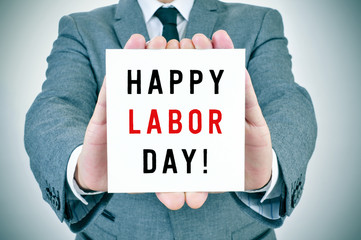 man shows a signboard with the text happy labor day