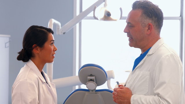 Dentist discussing work with nurse