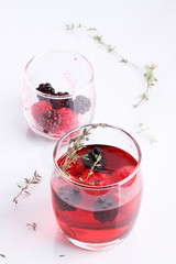 glass of berry drink with fresh fruits on marble table