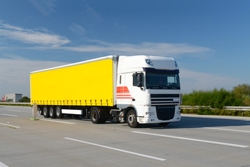 Fototapeta na wymiar LKW transportiert Waren auf der Autobahn - Logistik // Trucks transported goods on the highway - logistics
