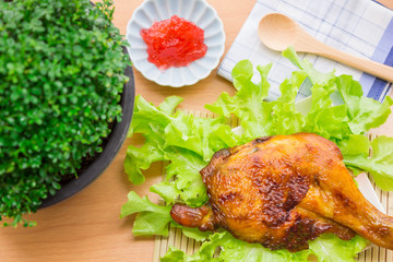 Eat grilled chicken with sauce on a wooden floor. Beautifully arranged unappetizing.