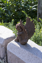 Engel sitzt auf dem Grabstein