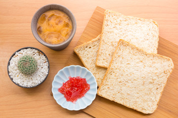 Bread with jam, strawberry tasty dishes on a wood floor. Ready to eat in the morning The appetizers are not hungry