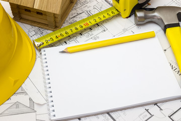 House under construction on top of blueprints with handwritten n