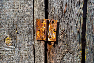 Rusty hinge on a wooden old door