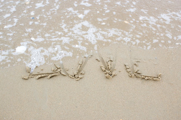 love word on beach with wave
