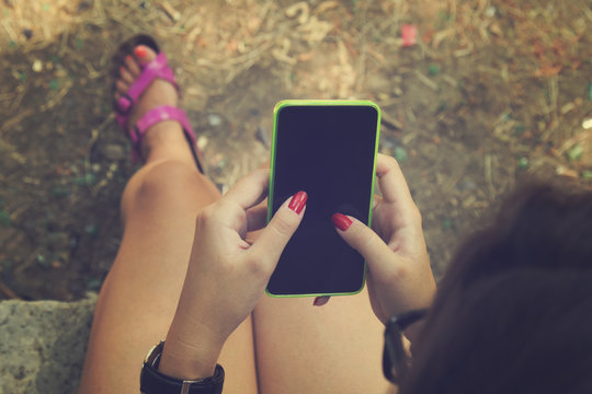 Young woman using cellphone outdoors.