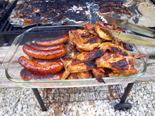 chicken and sausage cooked on a grill