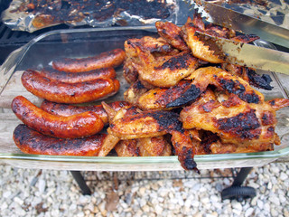 chicken and sausage cooked on a grill
