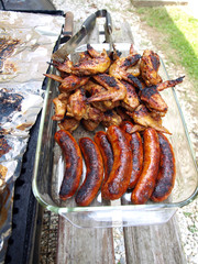 chicken and sausage cooked on a grill